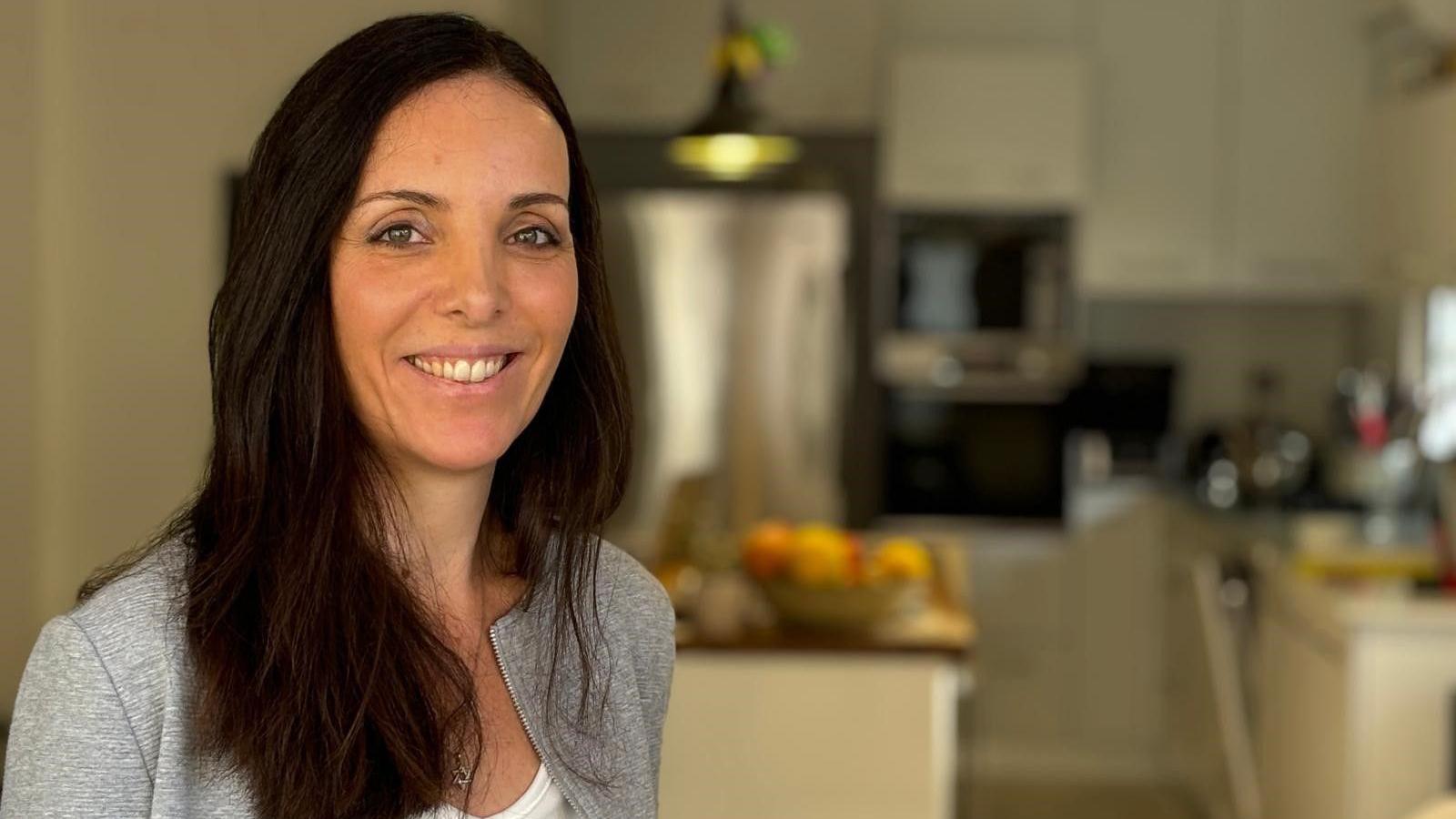 Shelly Lotan, a woman with dark hair, is pictured in her kitchen