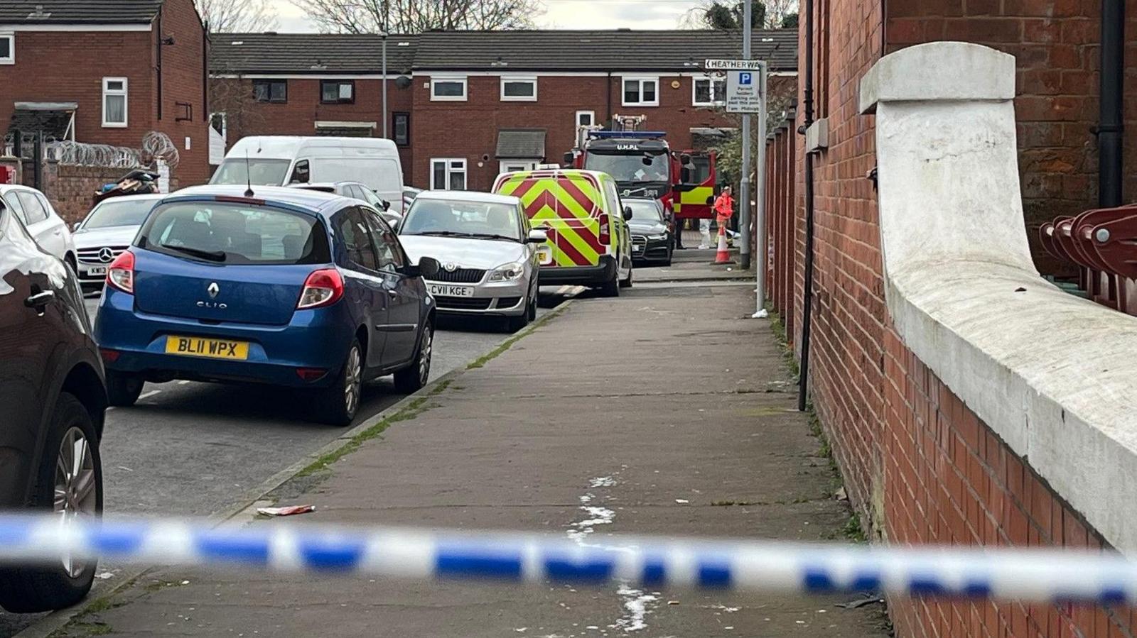 Close-up image of the road with emergency service vehicles parked up.