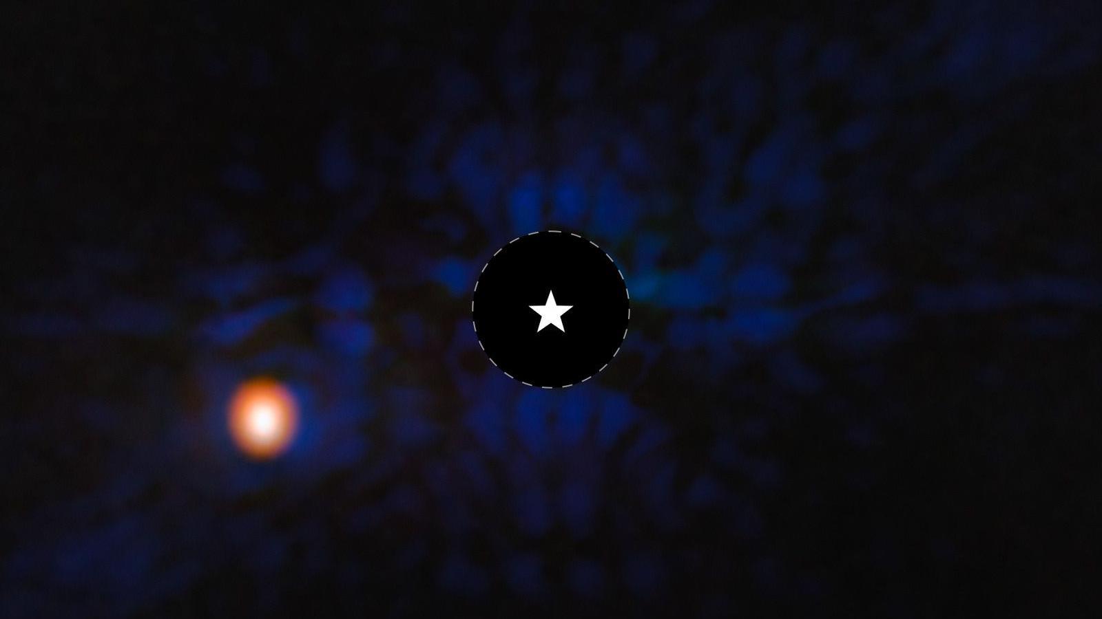 A photo from the space telescope of a blue-black background with a yellow-orange ball in the bottom left, and a star icon in the centre