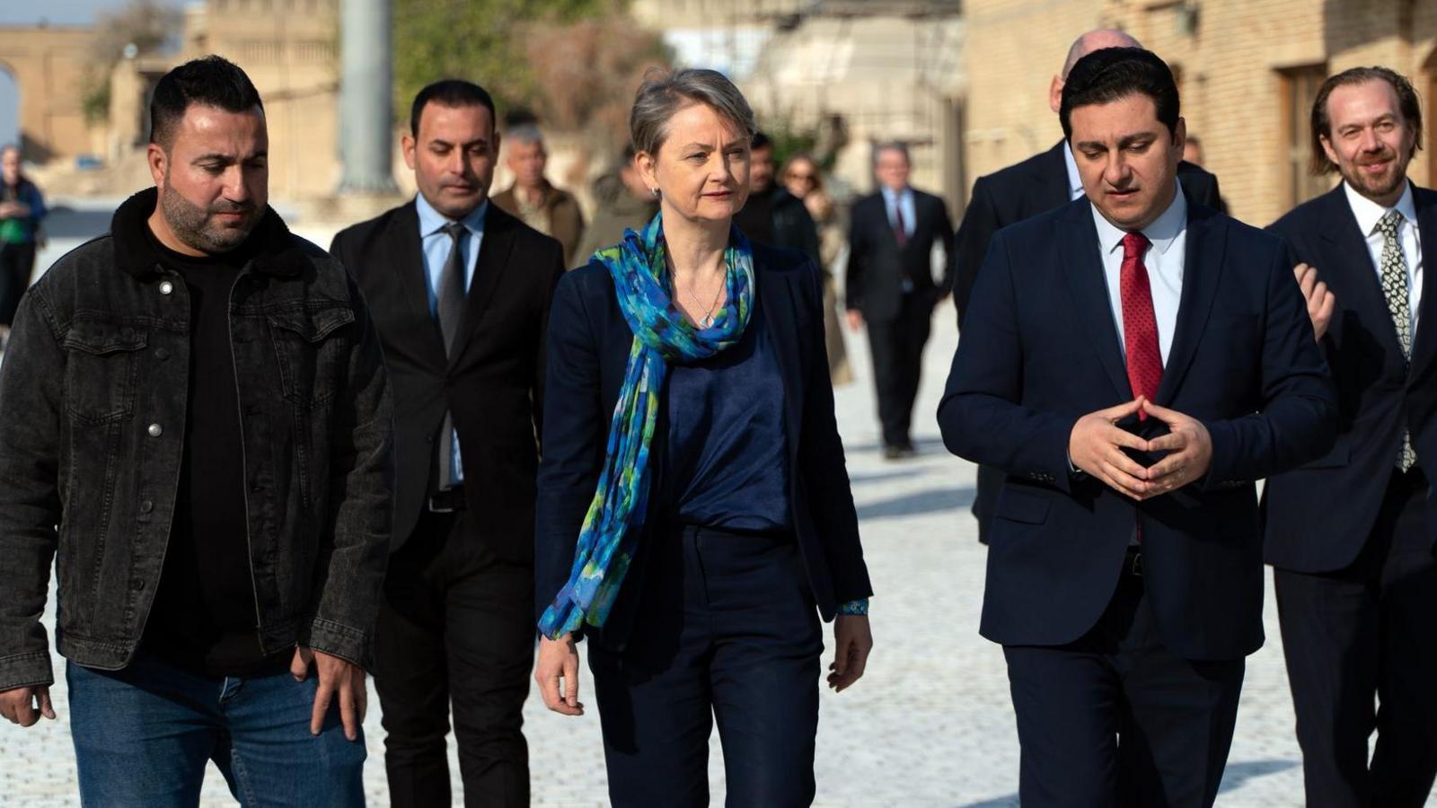 Yvette Cooper walking in Erbil while flanked by five men.