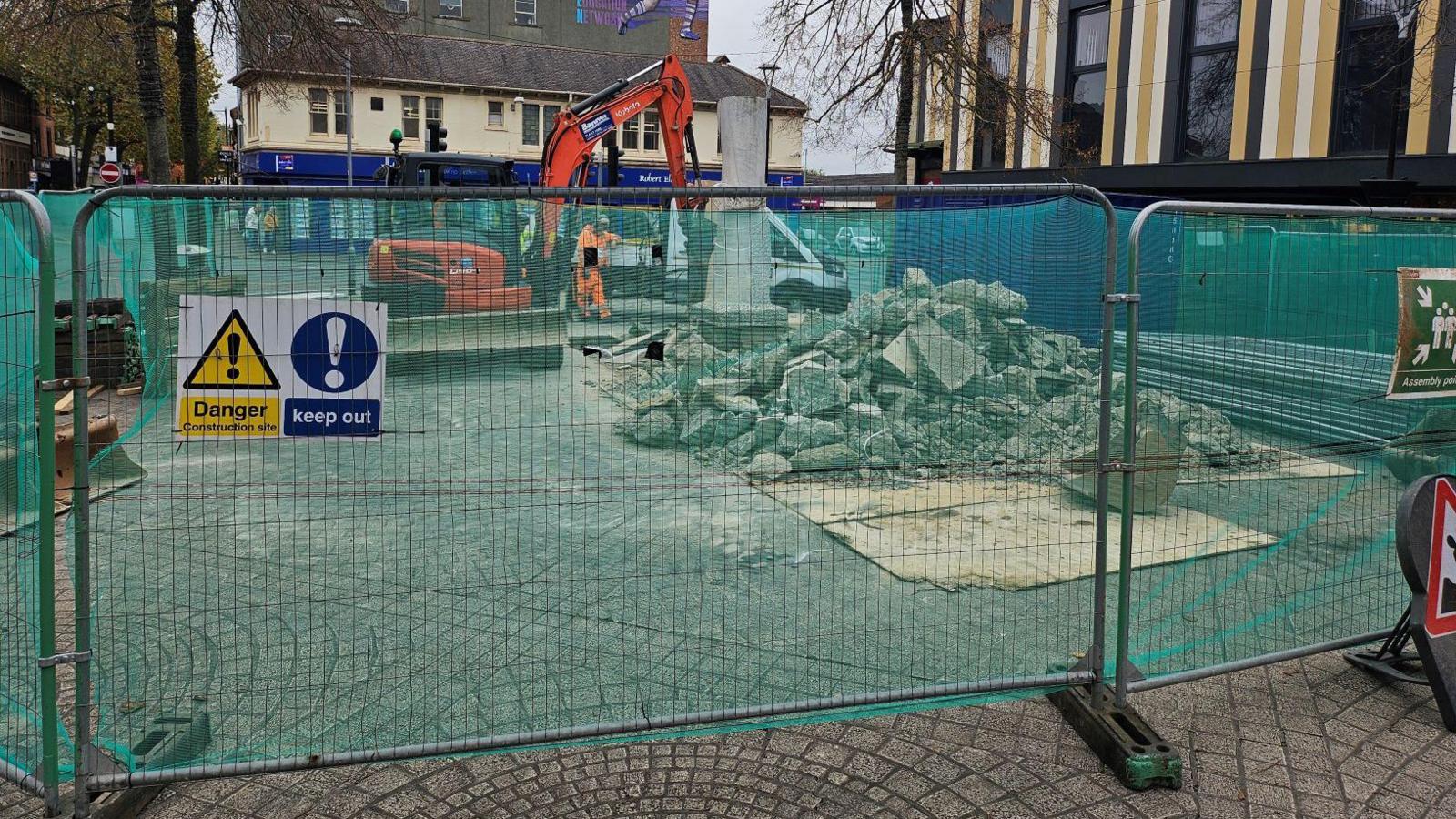 Workers demolishing the plinth that the Beeston stump rested upon in its prior location.