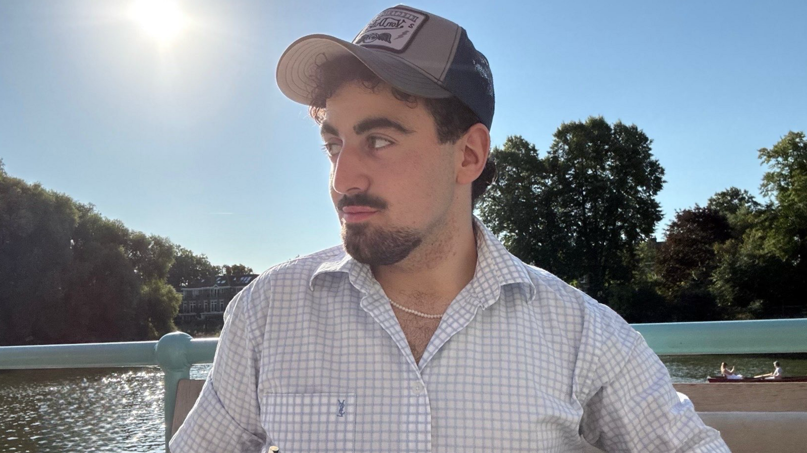 Hussein is in a cap looking to the side 