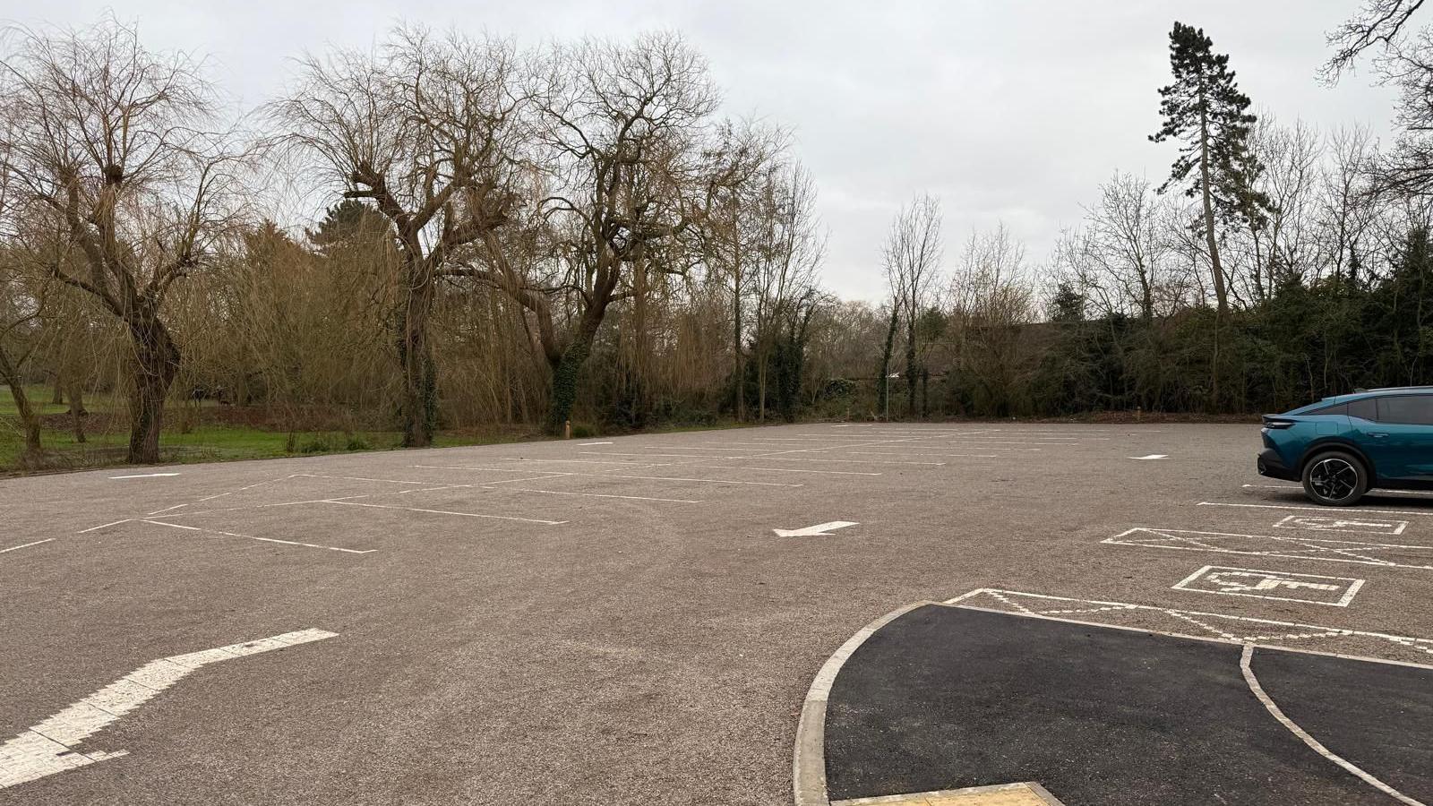 A recently resurfaced car park on the edge of a park