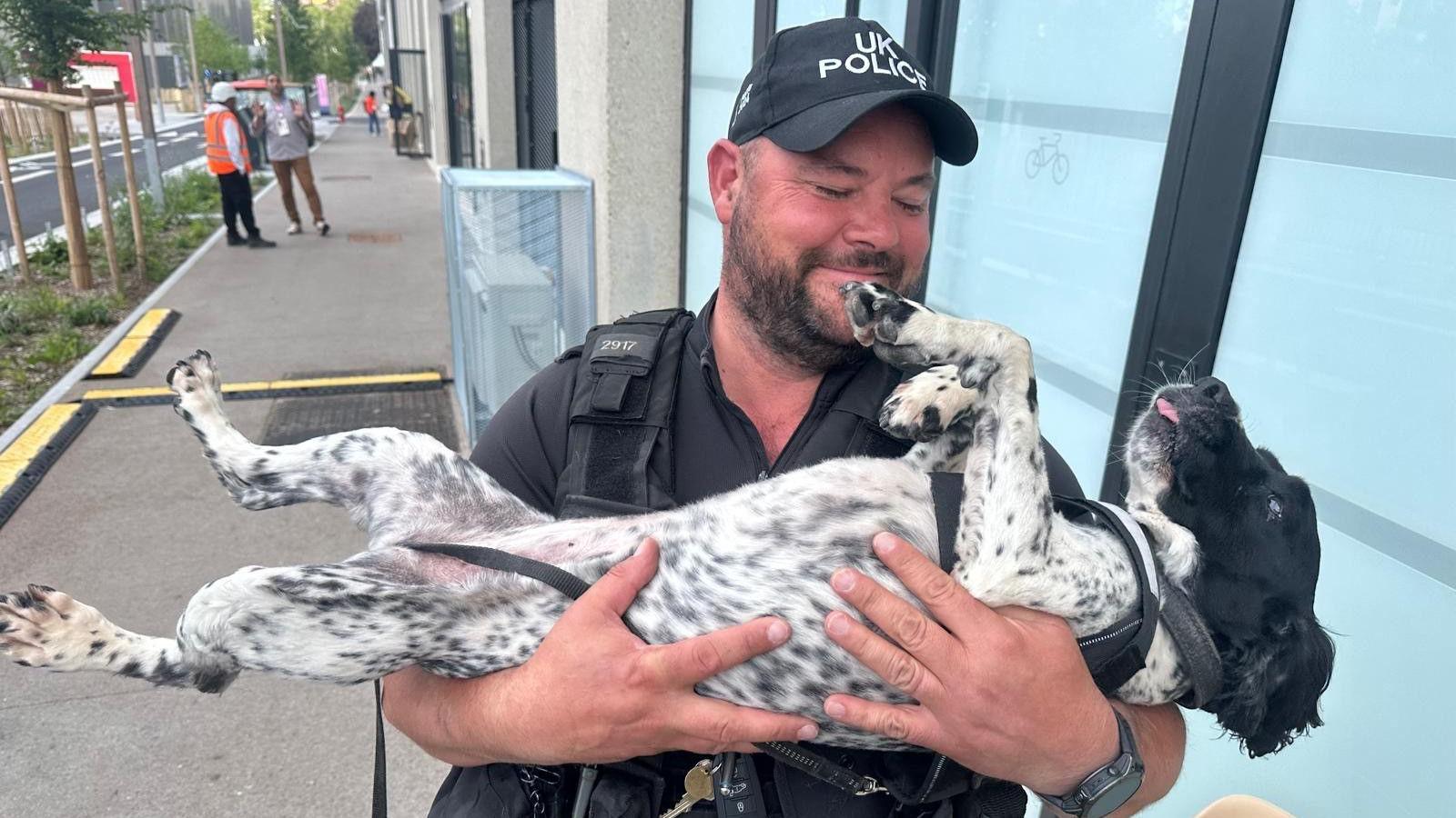 Richard cradling Emmy Lou the dog and smiling