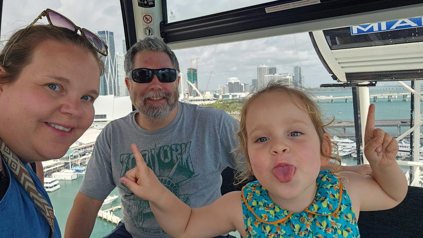 A selfie style photo of a woman, man and small girl in a gondola