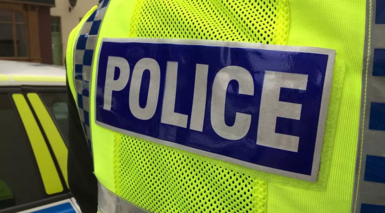 The back of a police officer in high viz vest