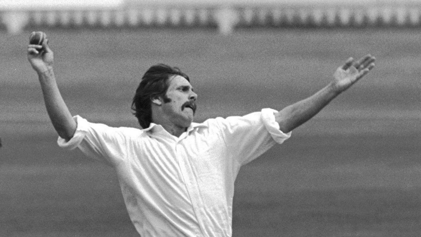Peter Lee with his left arm raised is about to bowl a ball with his right hand and his shirt sleeves rolled up in a black-and-white image 