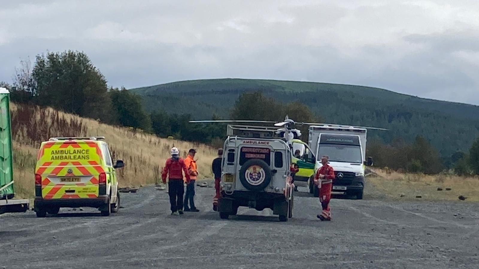 An ambulance and mountain rescue vehicle wait near to an air ambulance on a Borders hillside