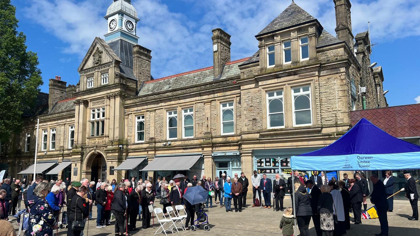 people observe silence at an event outside Darwen Town Hall