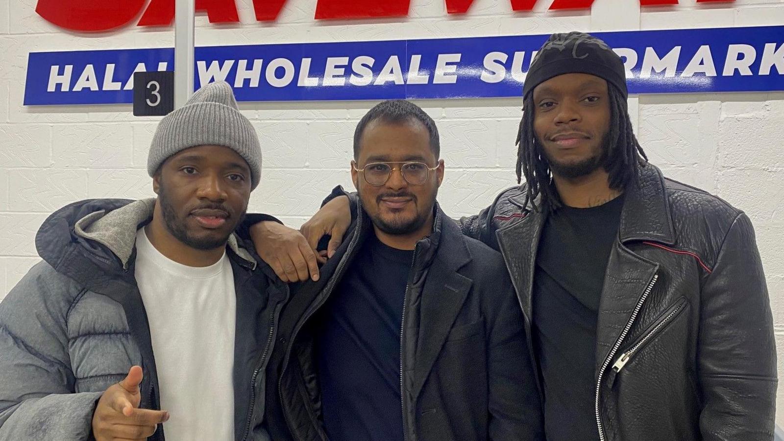 Konan, Kaysor Ali, and Krept are pictured in front of the Saveways sign inside the store.