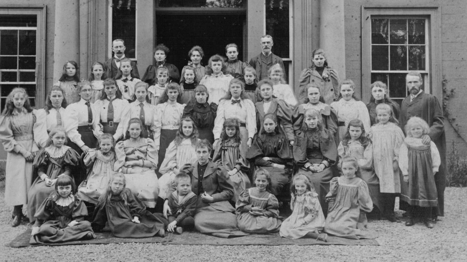 A’ chlann ‘s an luchd-teagaisg aig doras-aghaidh na sgoile, le Mgr Bruce fhèin air an làimh dheis.