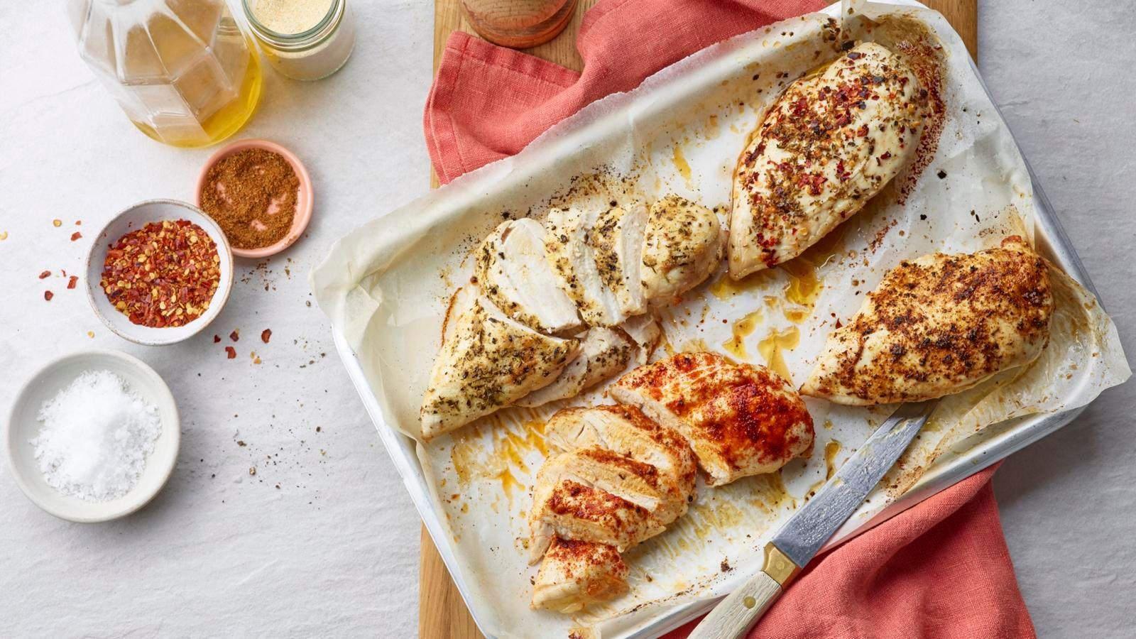 Baked chicken breast on a metal oven tray with a pink cloth