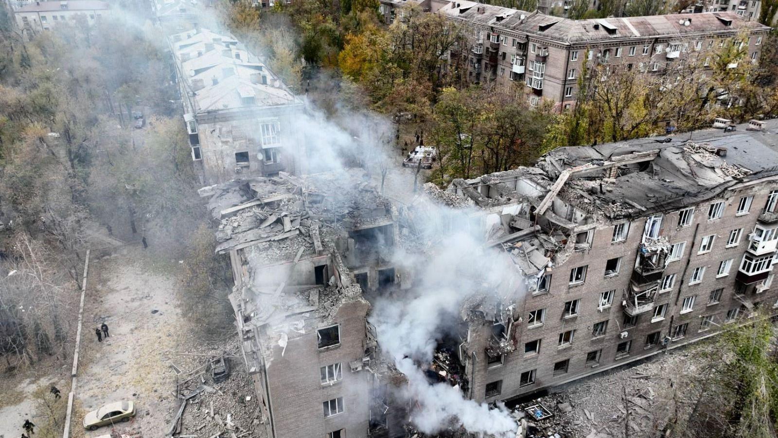 Smoke billows from the side of an apartment building that was struck by a missile