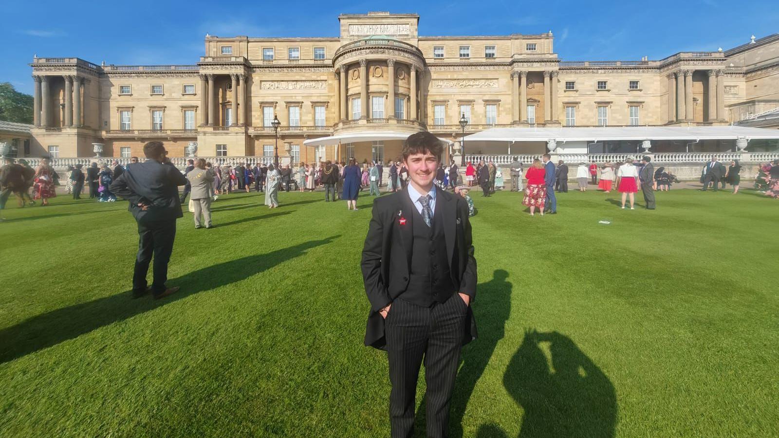 Charlie pictured smiling in the grounds of Buckingham Palace