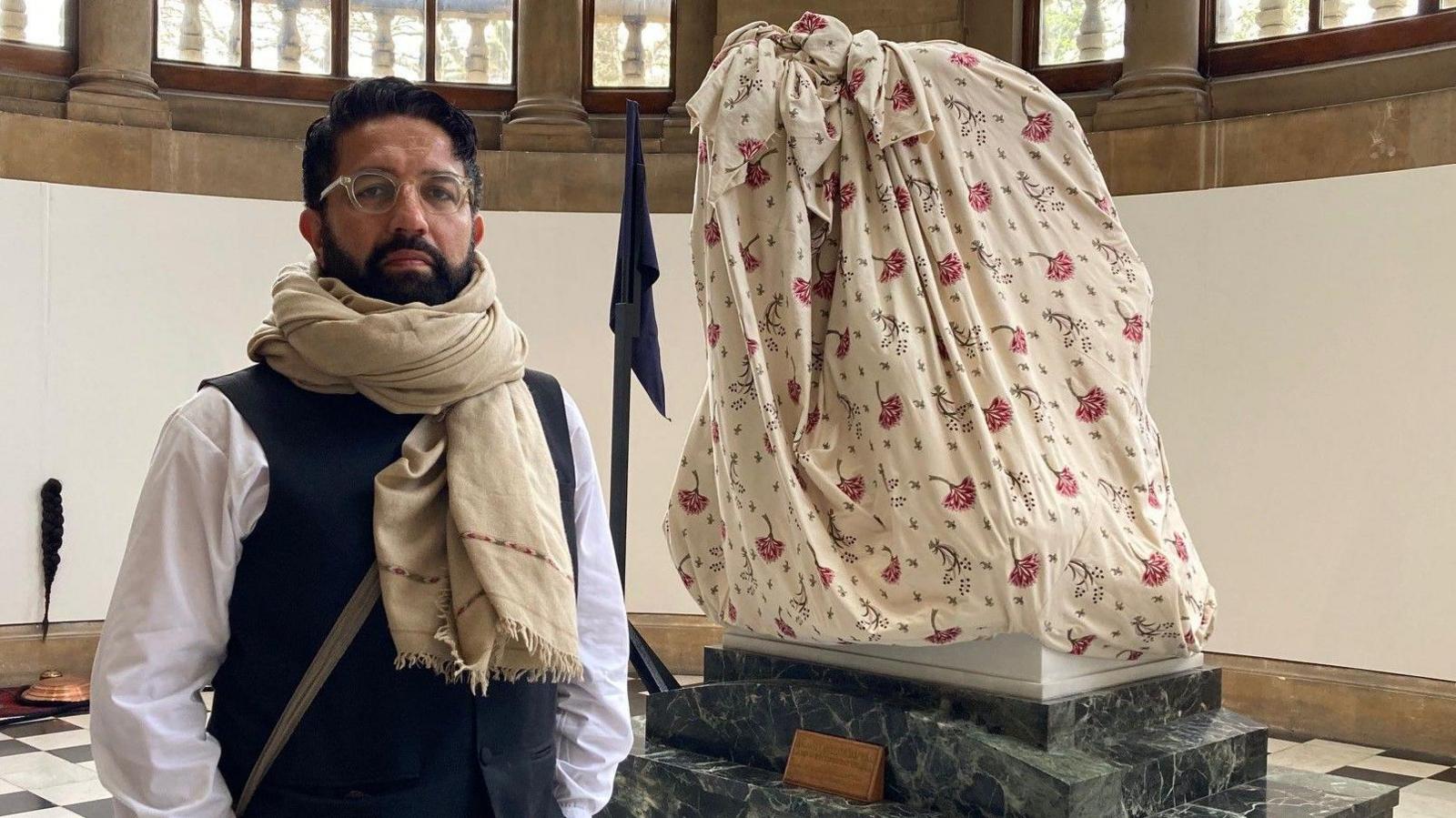 Artist Osman Yousefzada standing by one of his works inside Cartwright Hall