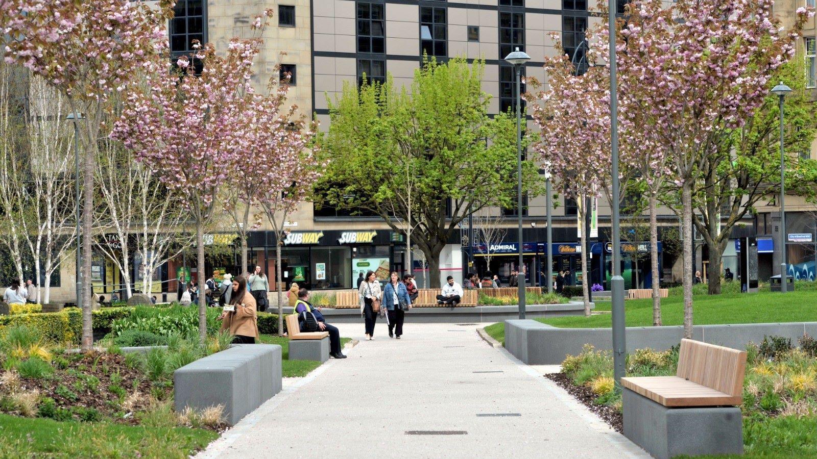Norfolk Gardens in Bradford city centre, a pedestrianised green space with walkways and benches.