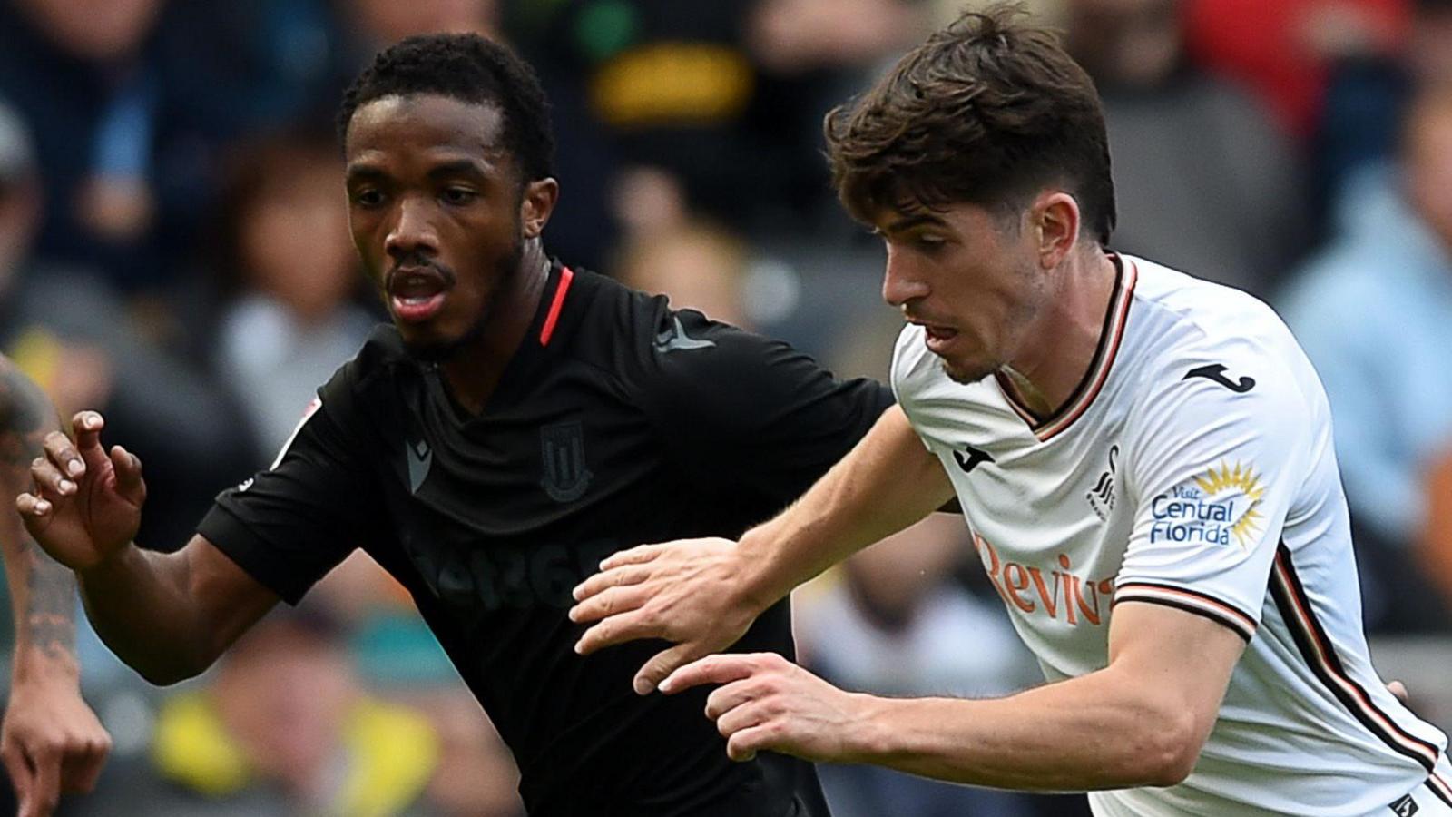 Josh Key (right) of Swansea City is challenged by Eric Bocat of Stoke City