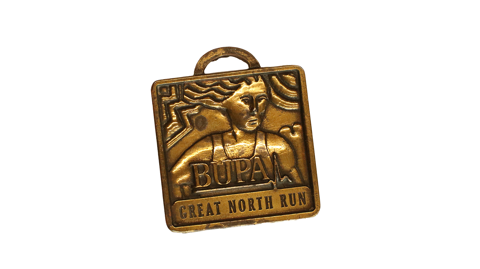 A square shaped gold medal with a female runner on with long hair. It reads 'Bupa Great North Run'.