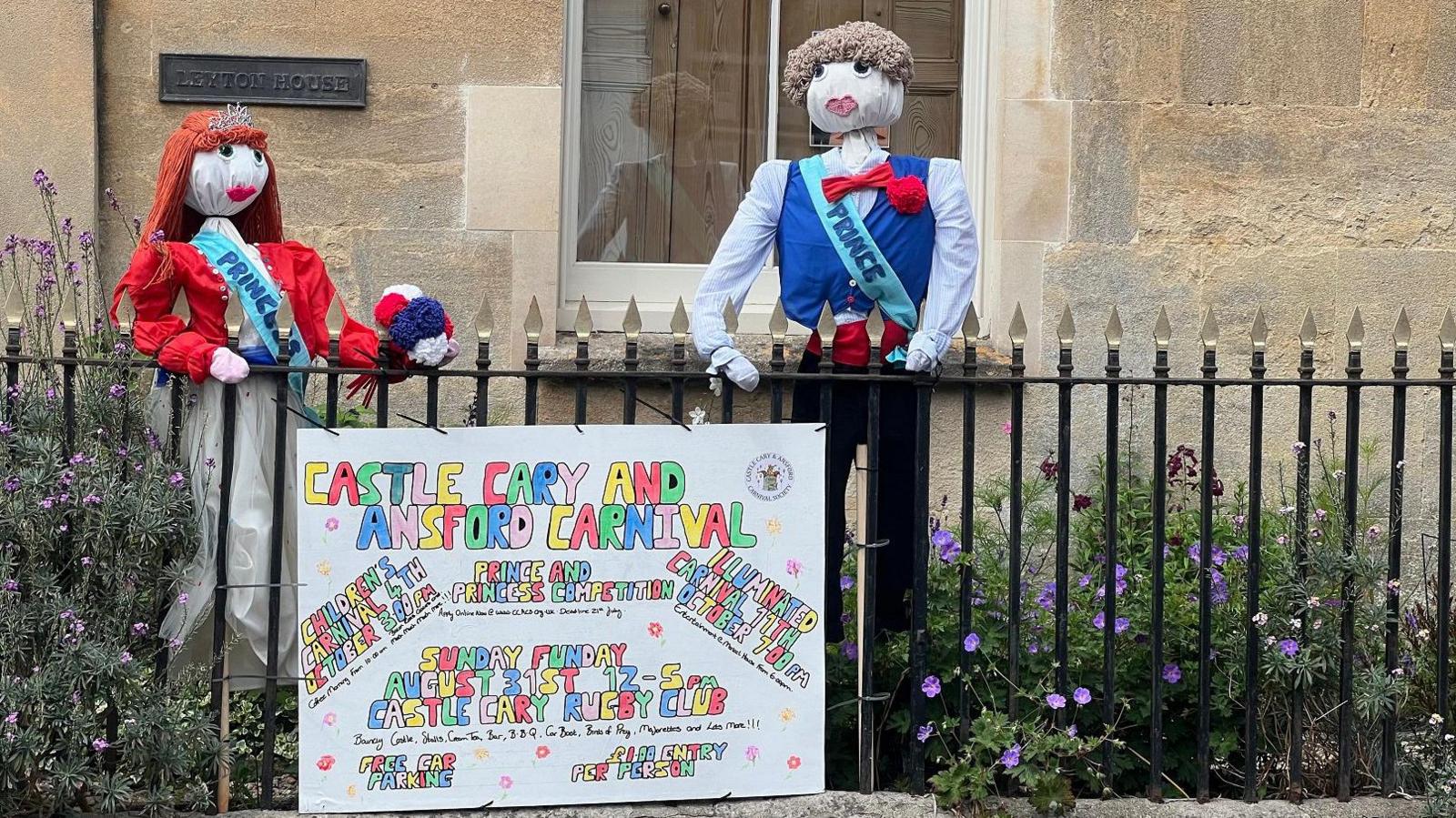 Two scarecrows, one male wearing a sash saying prince and one female wearing a sash saying princess