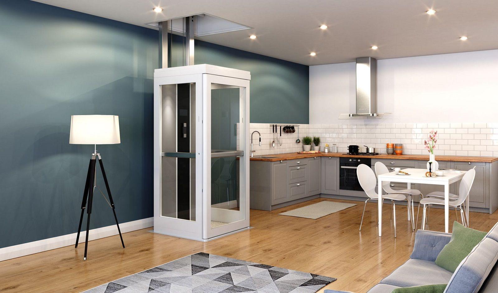 A kitchen which is grey. A white lift sits beside the kitchen island connecting two floor together. 