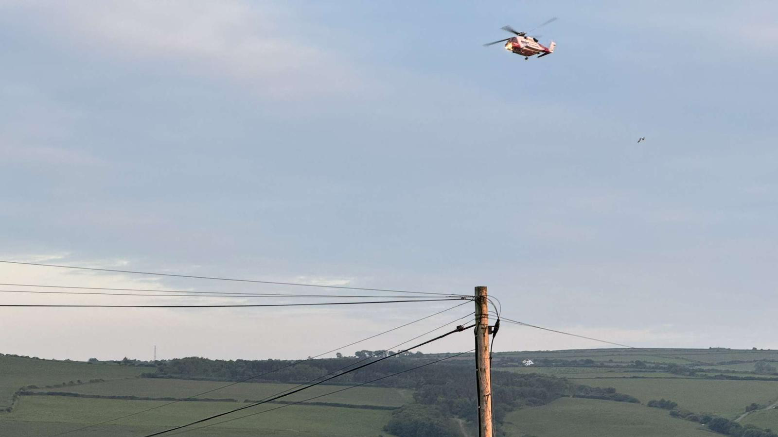 Helicopter flying over green hills 