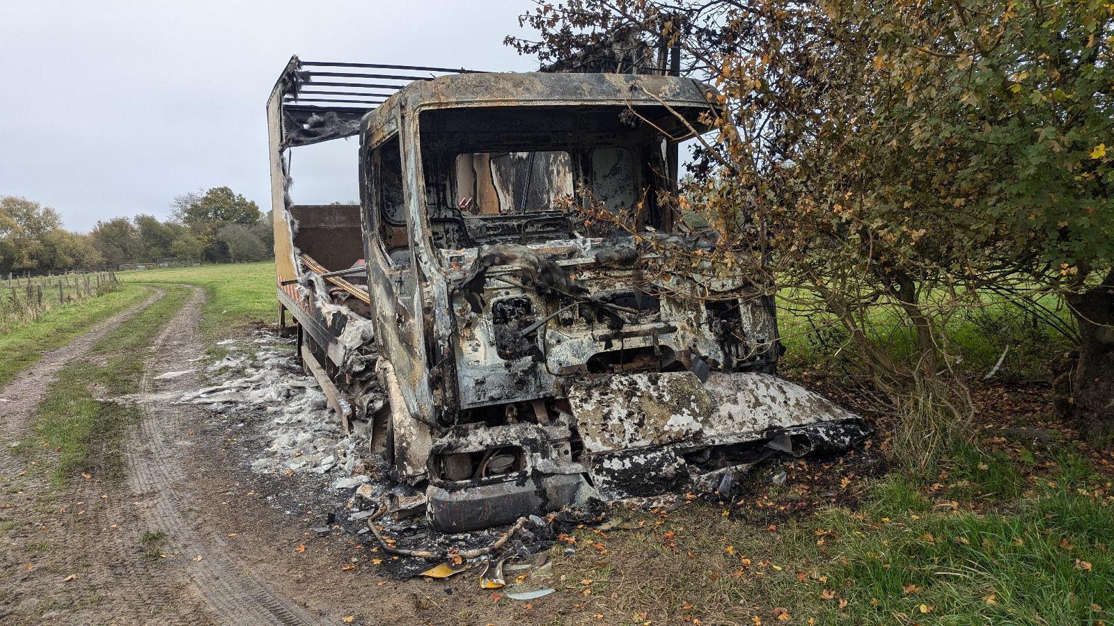 Front view of burned lorry next to track at nature reserve