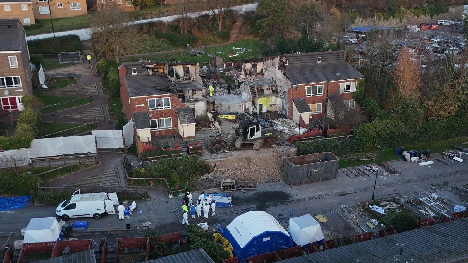 Police and other services in early December at the scene in Benwell. The middle of the row shows an exposed concrete interior with rubble outside.