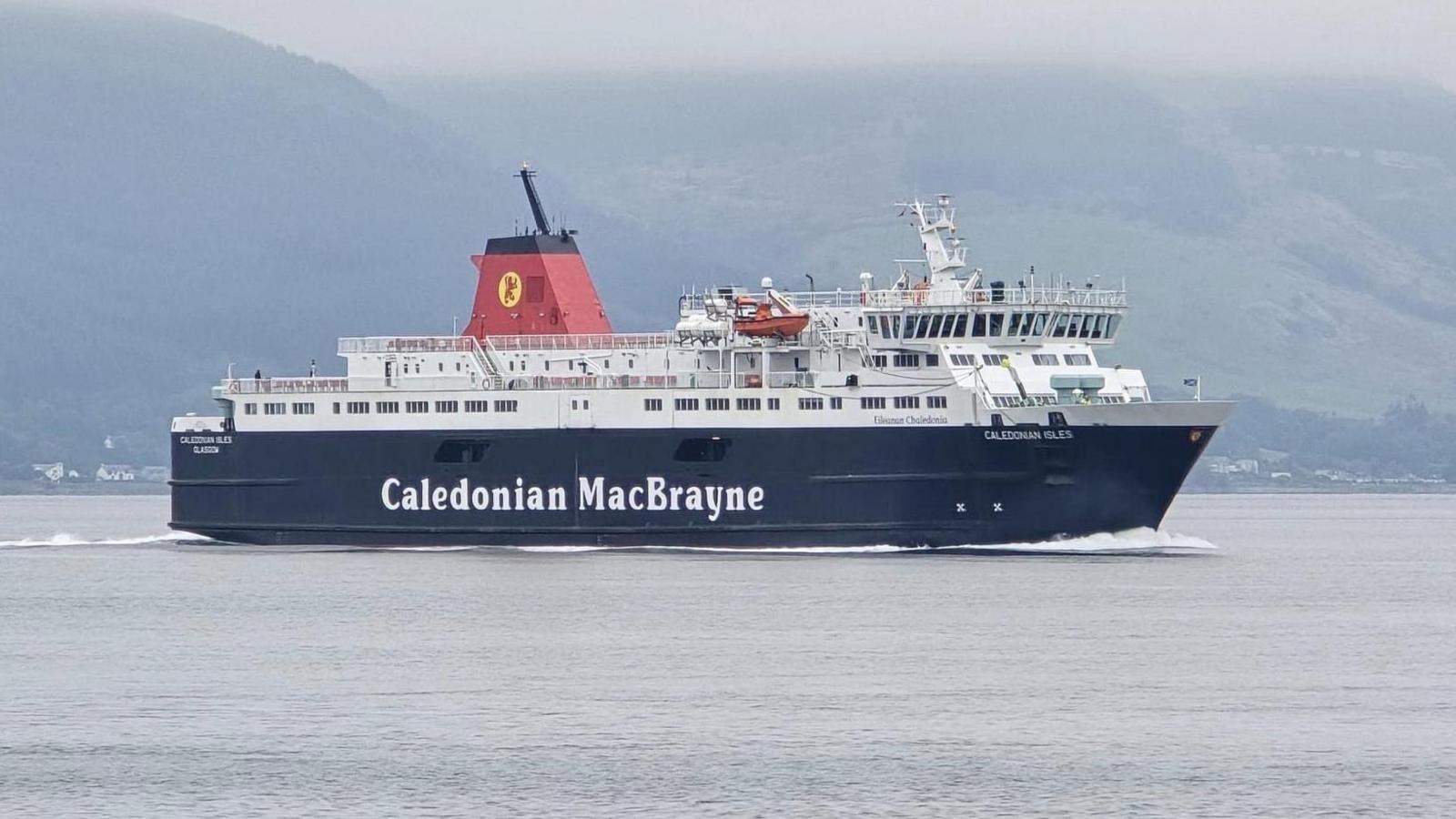 A black and white ship, Caledonian Isles, seen sideways on, sailing with hills in the background