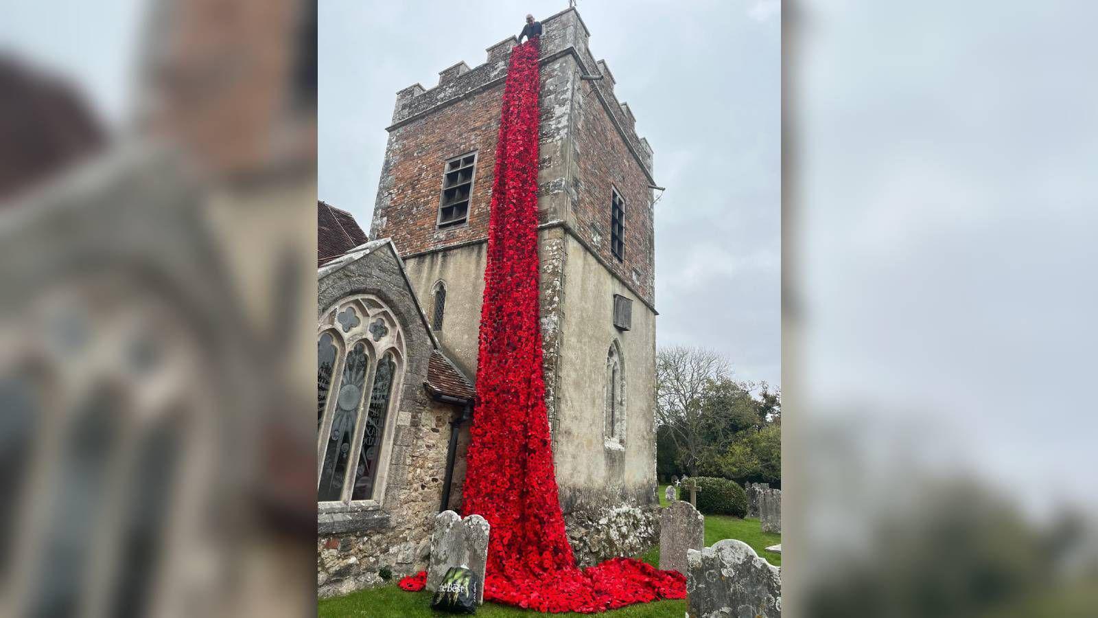 A waterfall of knitted poppies coming down the side of Boldre church in the New Forest.