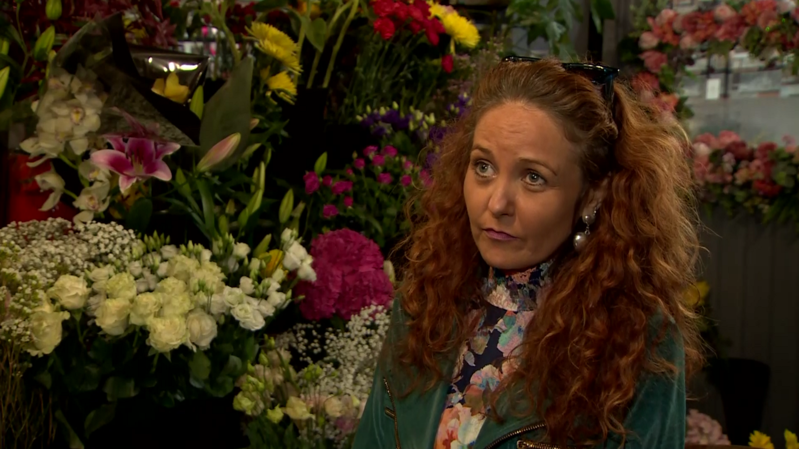 Marie Dargan, owner of Johnston Florists, standing to the right of the frame with flowers behind her 