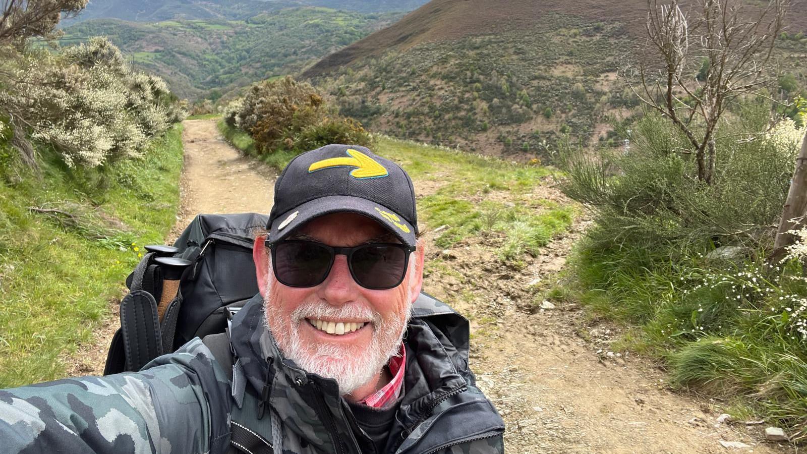 Ricki Nash, brother of Cheryl Grimmer, smiling at camera with hills in background