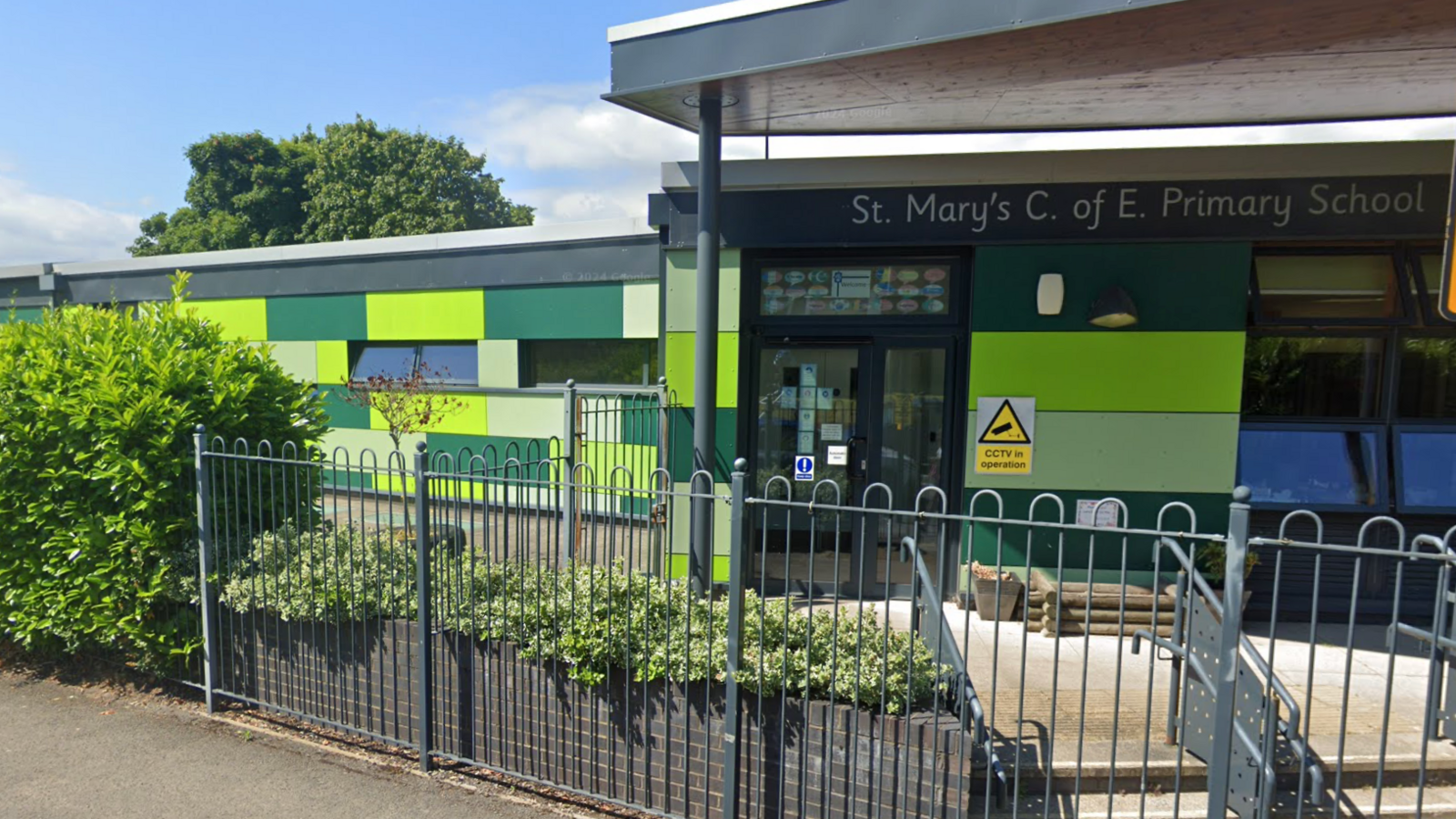 The outside of a school building with the sign - St Mary's Church of England School. 