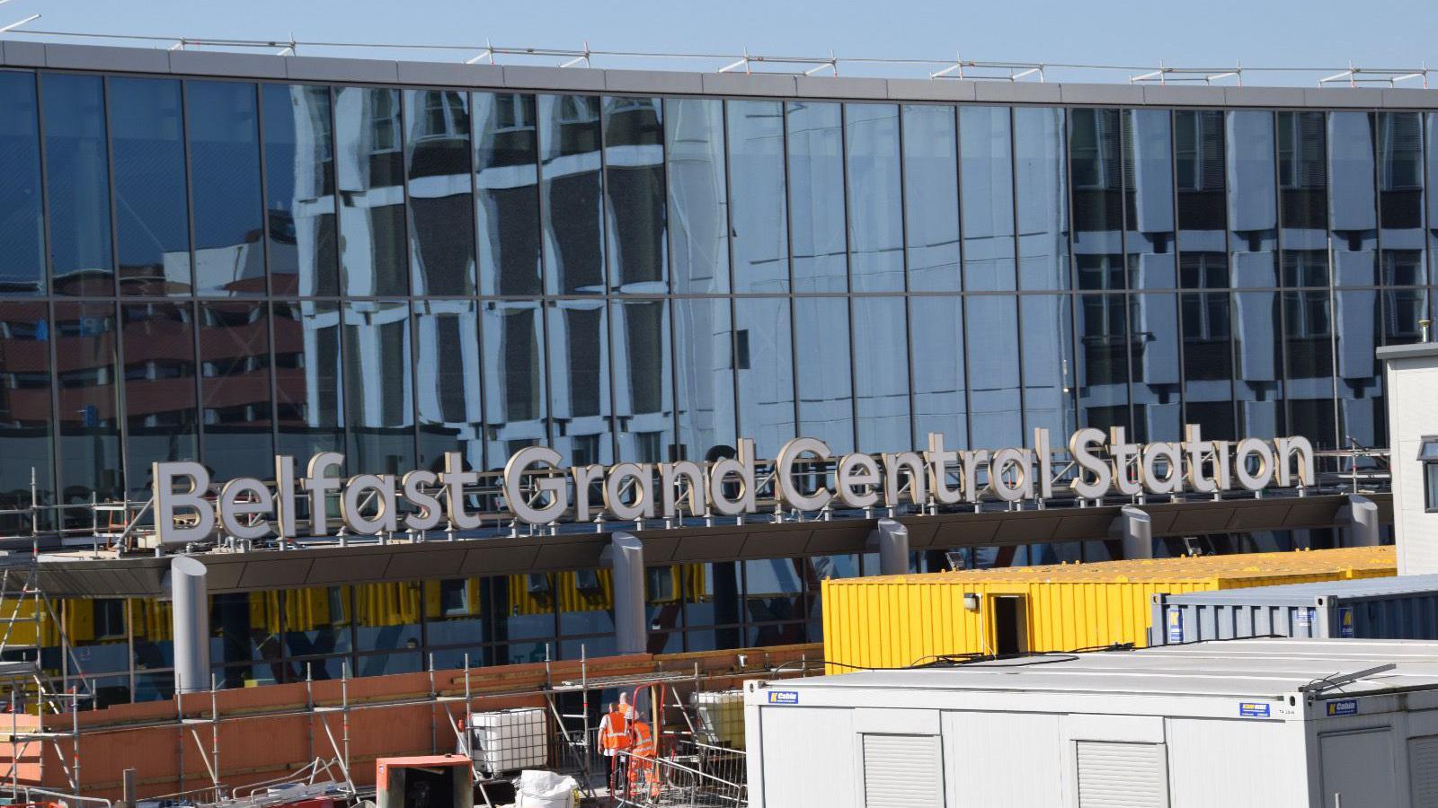 A train station with large signage spelling out Belfast Grand Central Station. 