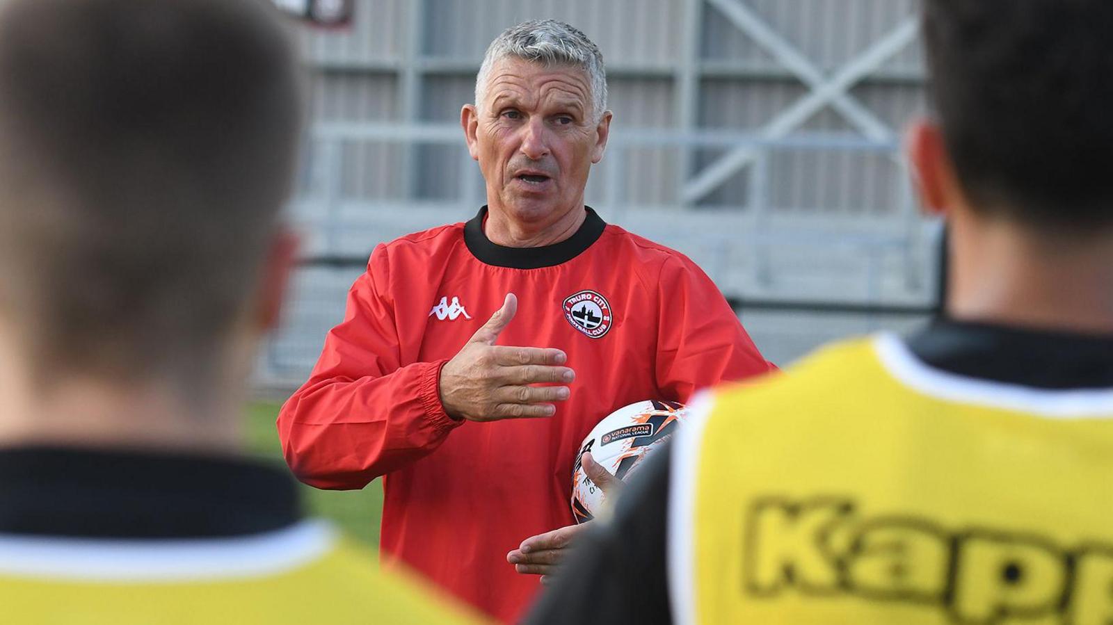 Truro City manager John Askey delivers a team talk to his players during training