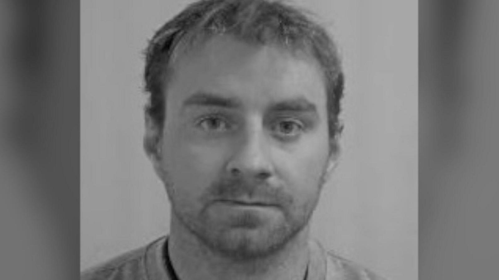 A black and white mugshot of Jordan Corkill who looks directly at the camera, the image is black and white.