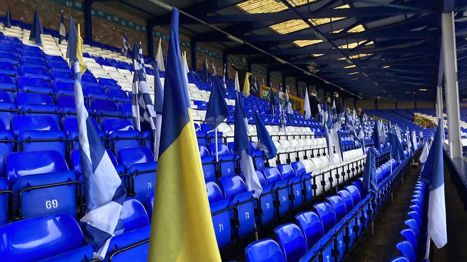 Blue and white and blue and yellow flags are placed between Goodison Park seats