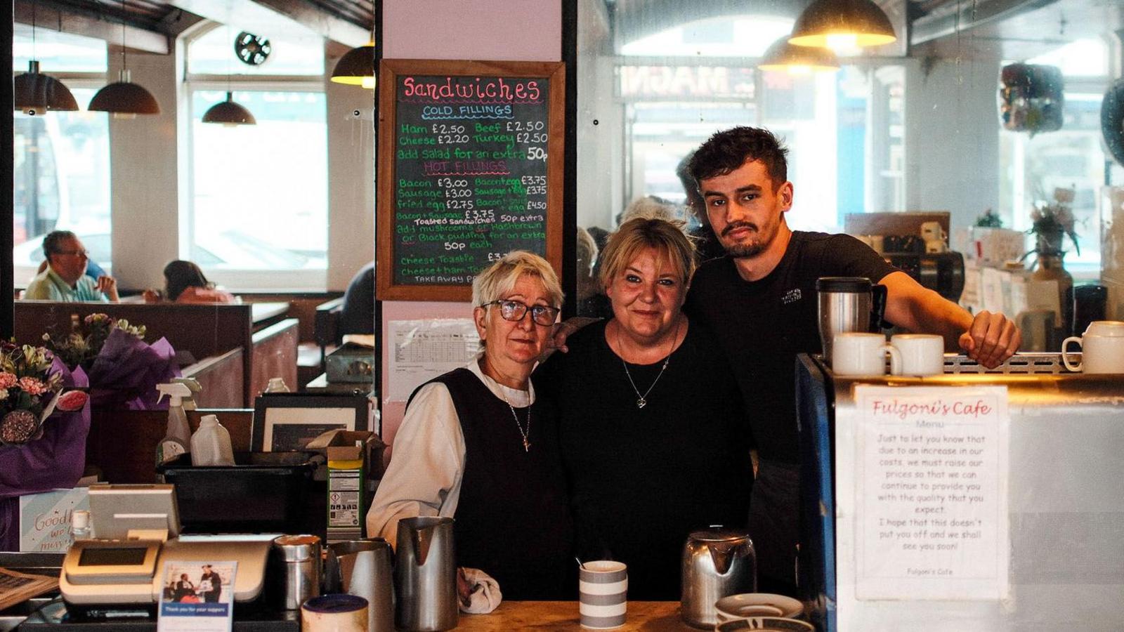 Three generations of the Fulgoni family stand together at the counter of the cafe