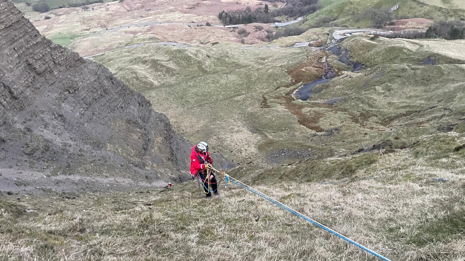 A rope rescue lowering a person off a hill