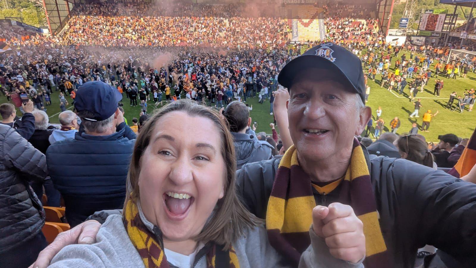 A selfie shot of a daughter and her father both wearing claret and amber scarves at the final game of Bradford City Football Club's latest season.