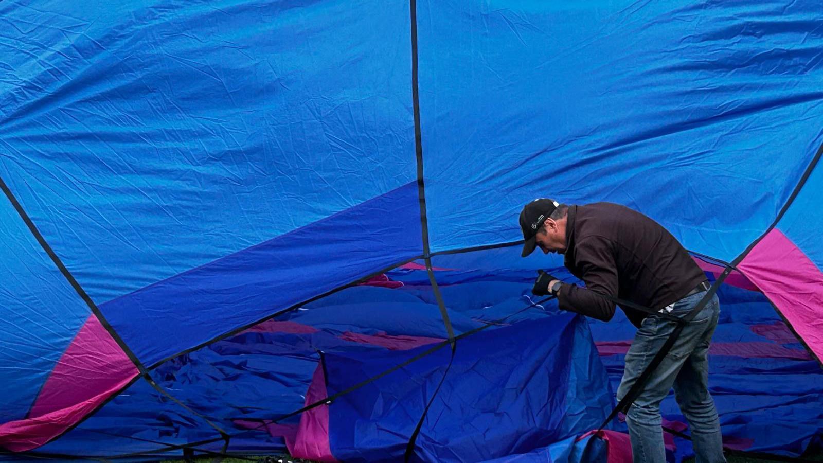 Man working on a blue hot air balloon