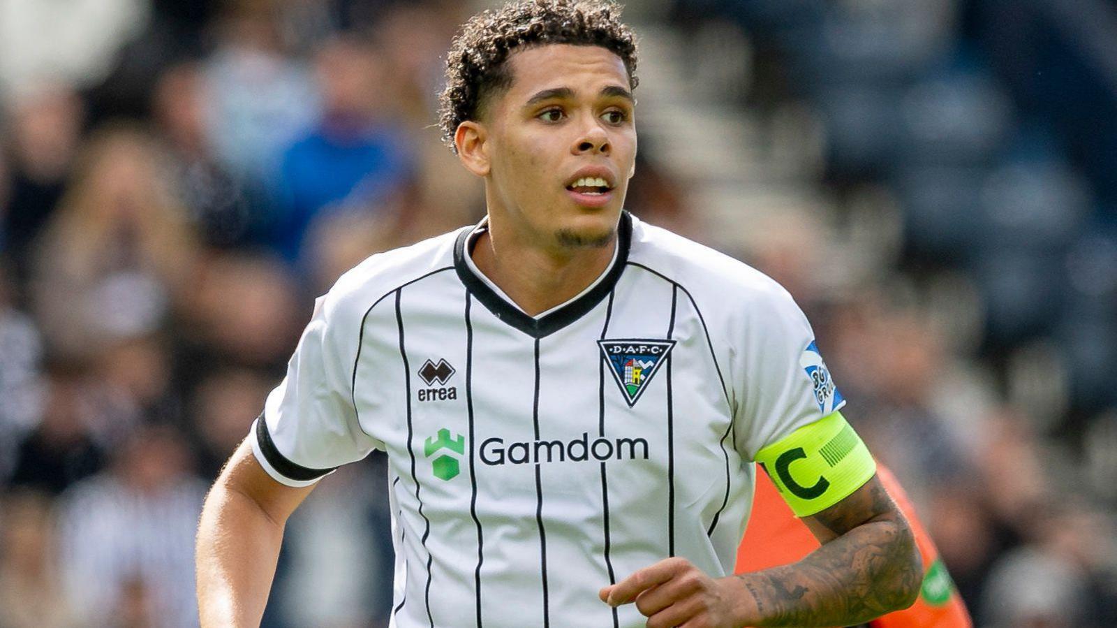 Jeremiah Chilokoa-Mullen in action for Dunfermline in their white home shirt, with the captain's armband on his left arm