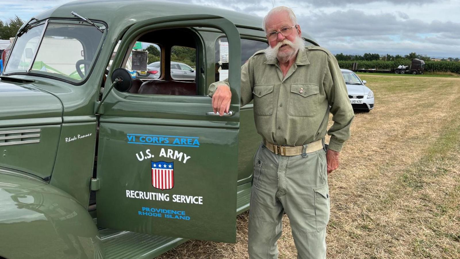 Roy Halsall, standing next to his  American wartime vehicle that he restored, wearing a flamboyant moustache