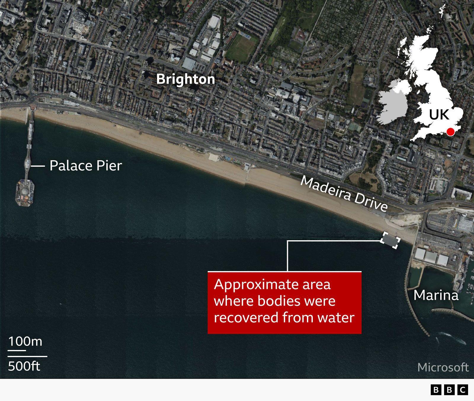 Një hartë satelitore e bregdetit të Brighton-it në Mbretërinë e Bashkuar që tregon vijën bregdetare, me etiketa për "Brighton", "Palace Pier", "Madeira Drive" dhe "Marina". Një kuti e kuqe nxjerr në pah zonën e përafërt në det të hapur ku u nxorën trupa nga uji, në lindje të skelës pranë marinës. Një hartë e vogël e futur në insert e Mbretërisë së Bashkuar shënon vendndodhjen në Anglinë jugore, dhe një shirit në shkallë tregon distancën.