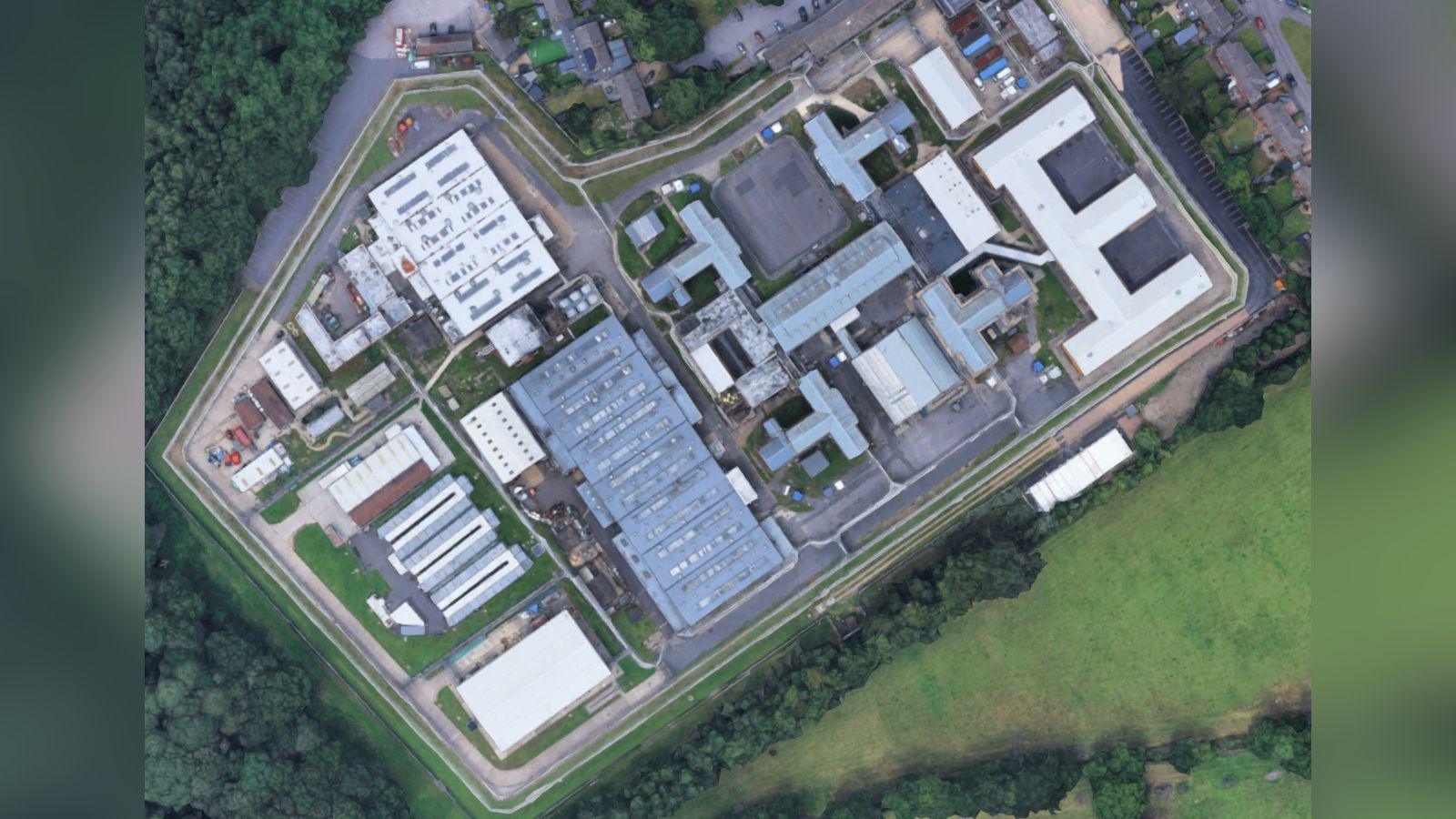 A satellite view of a prison surrounded by trees.