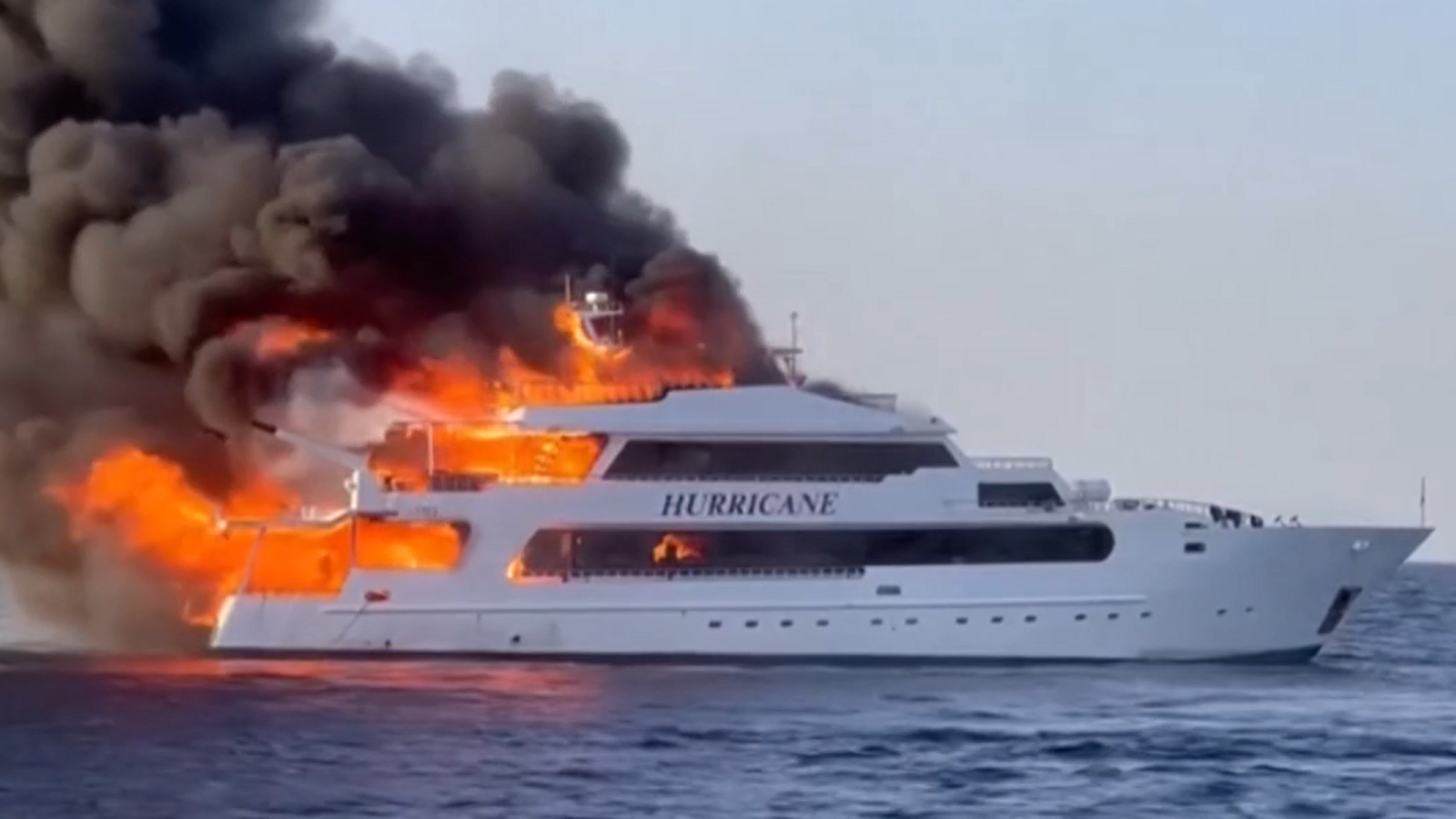 A large boat with "Hurricane" written on the side. There is a large fire coming from the back of the boat.