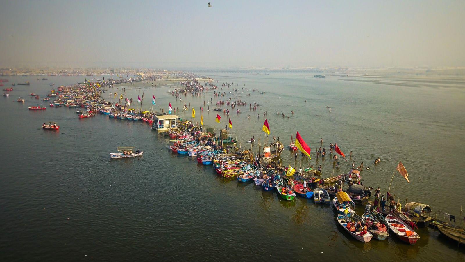 The row of boats stands where the darker waters of Yamuna (left) meet the lighter, shallower waters of Ganges (right)