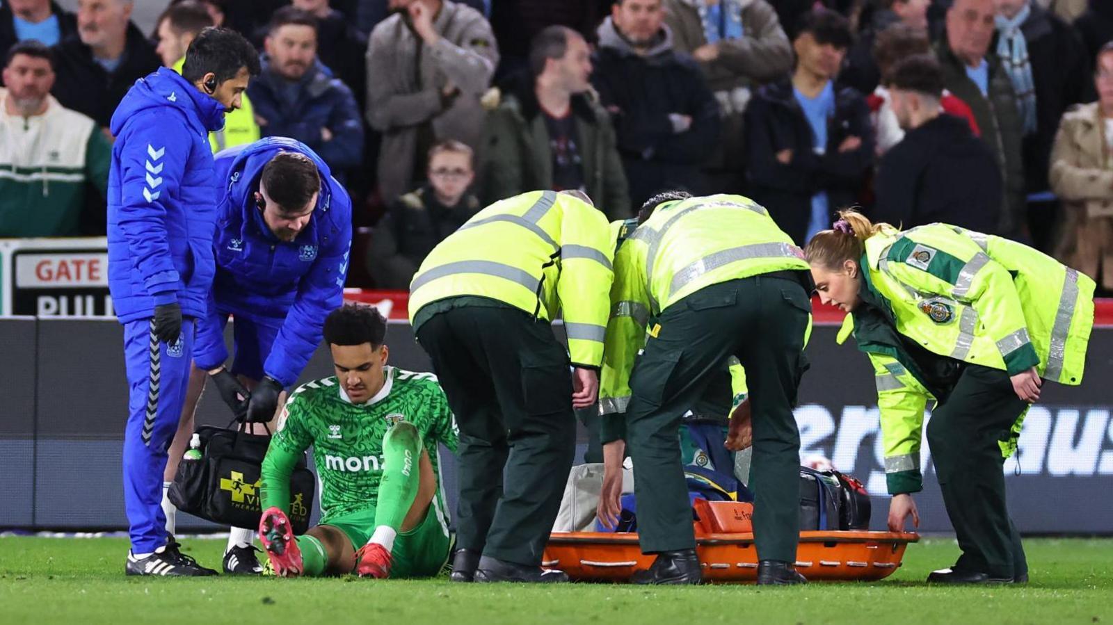 Oliver Dovin sat down, about to be taken off on a stretcher with an injury