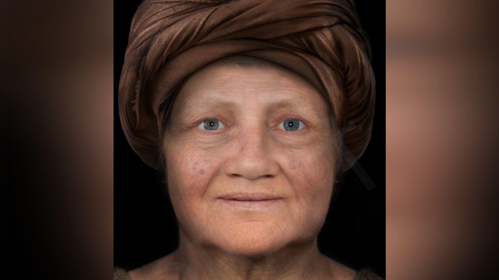 The early reconstruction of the face of The Kendal Woman. She is a middle-aged woman wearing a dark turban and she has blue eyes.