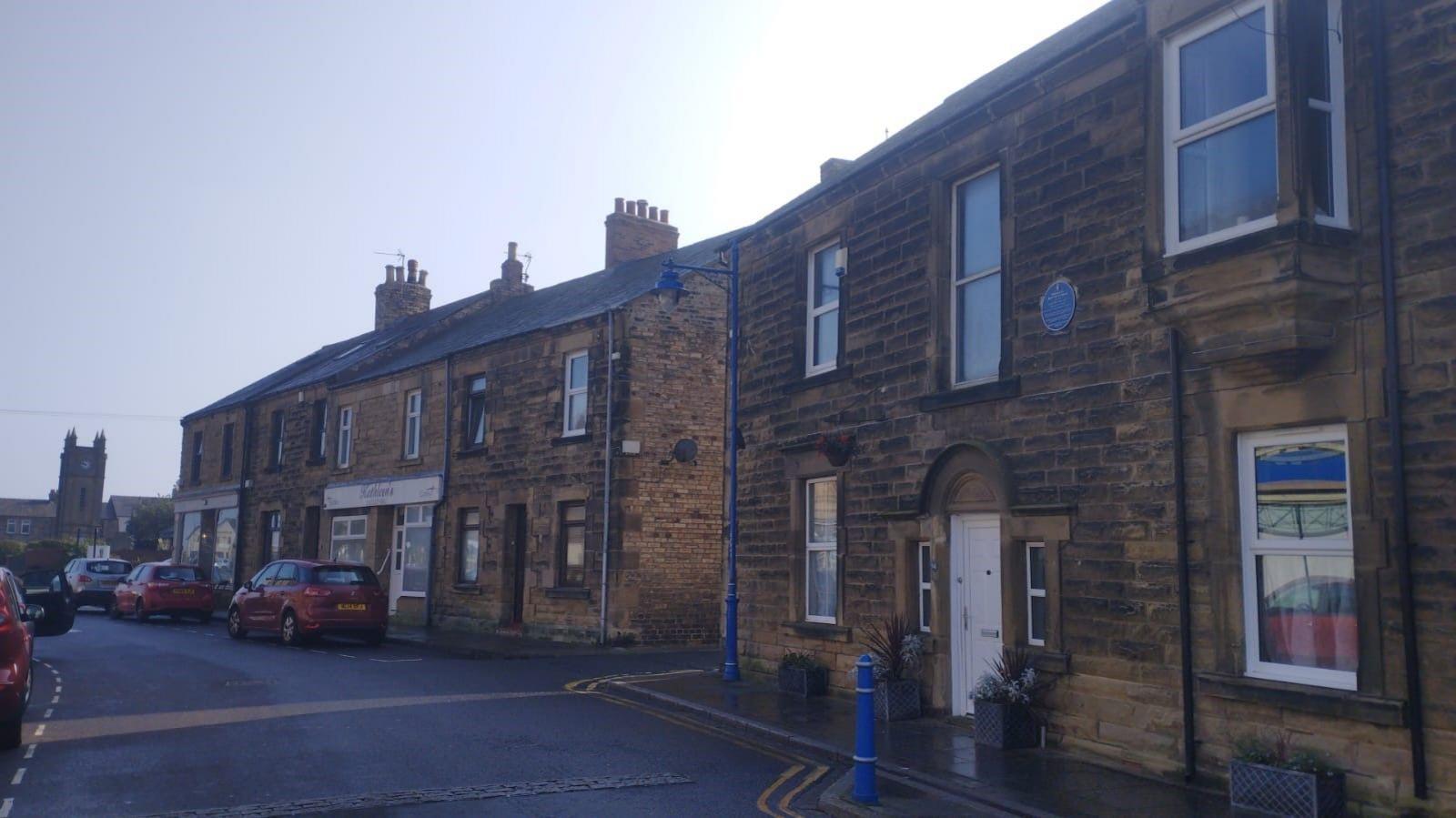 A terraced Victoria street running down to the clock tower at Amble