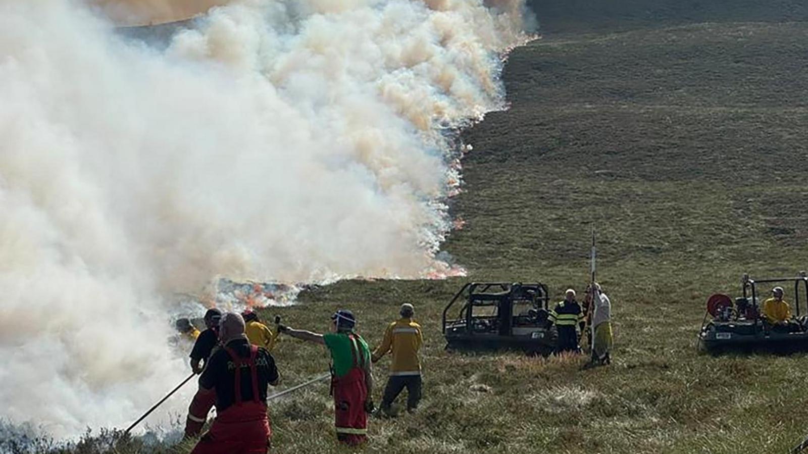 firefighters beating down flames on wildfire